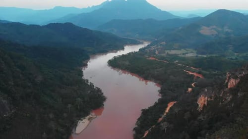 Muddy River Winding Through Vast, Verdant Mountain Range and Valleys