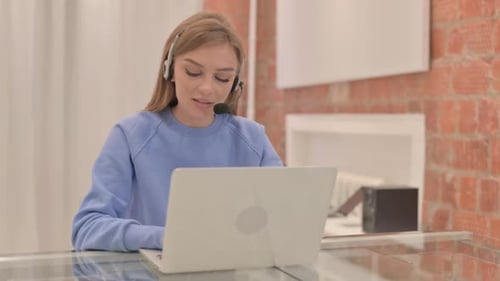 Young Woman with Headset Talking with Customers Online in Call Center