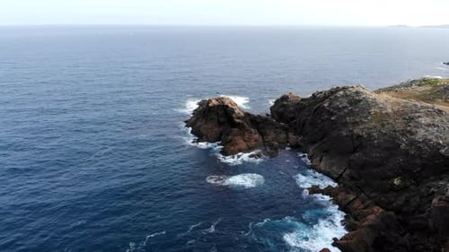 Aerial Rock Formation With Crashing Waves Jagged Promontory Foamy Surf Turquoise Currents Seabird