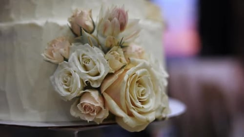 Close-up of Frosted White Wedding Cake Decorated with Floral Bouquet of Pretty Roses, Dolly Out
