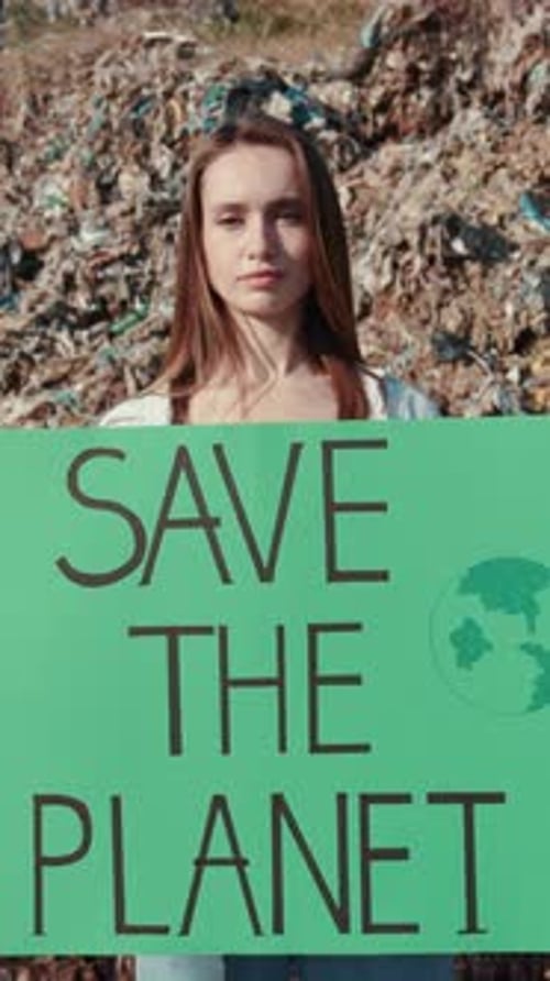 Woman Holds Save the Planet Sign at Landfill