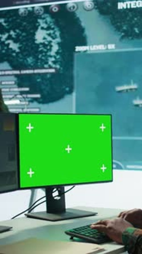 Person Typing on Keyboard with Green Screen Monitor
