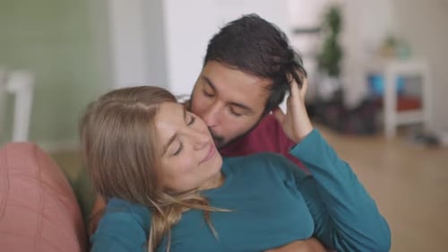 Loving Couple Embracing on Couch Indoors