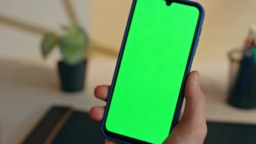Hand Holds Phone with Green Screen for Compositing