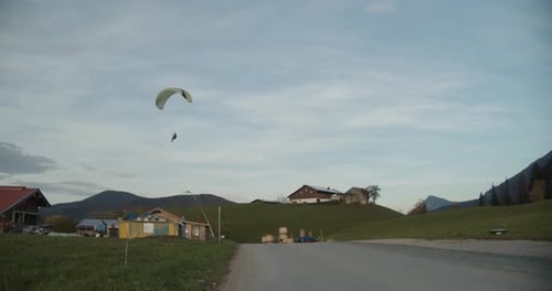 Full shot, Paraglider landing in the grass in Chiemgauer Alpen.