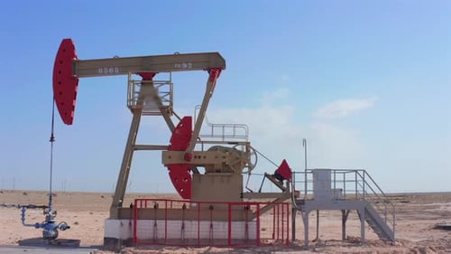 Oil Pump Jack Working in Desert Landscape