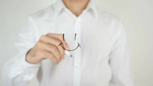 Person Drawing a Smiley Face on Glass