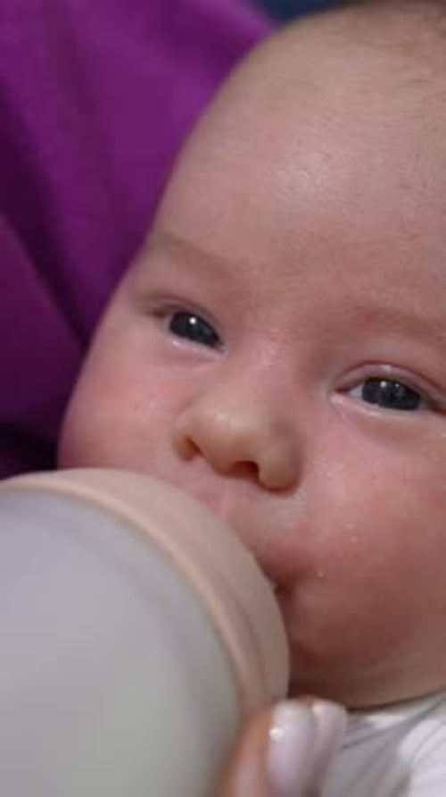Baby Drinking from Bottle in Close Up