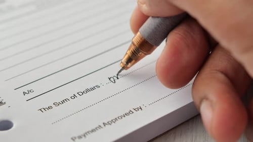Um homem escreve o pagamento devido em um formulário em papel