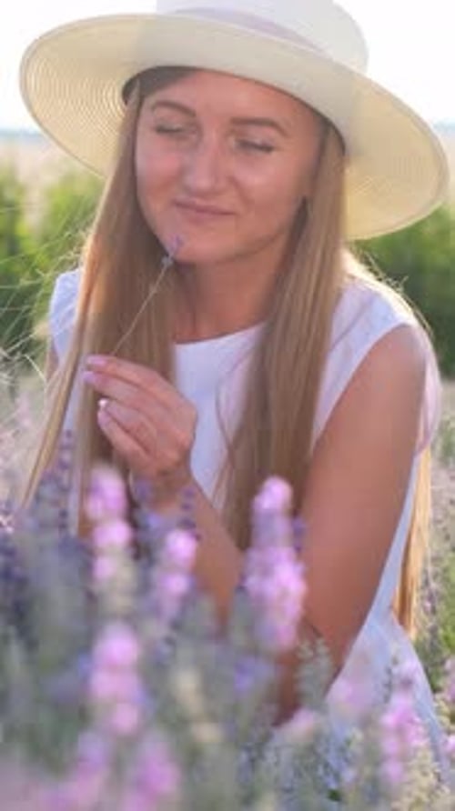 Vidéo verticale d'une belle femme au chapeau sur un champ de lavande