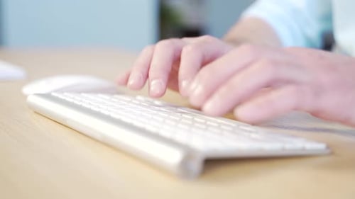 Close-up of a businessmen man's hands typing a desk on a keyboard. Man working on computer at table