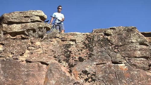 Ciclista de montaña disfrutando de deportes extremos al aire libre al borde de un acantilado