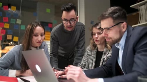 Colleagues And Clients Talking Strategy With Laptop And Tablet In Creative Office Productive