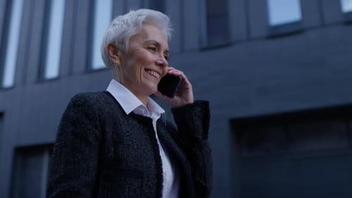 Smiling Senior Woman Talking on Phone Outside Office