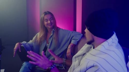 Homme donnant une interview à une femme dans le studio d'enregistrement