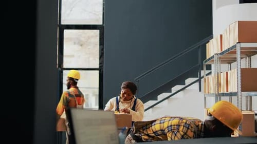Workers Pack Boxes at Indoor Warehouse Facility