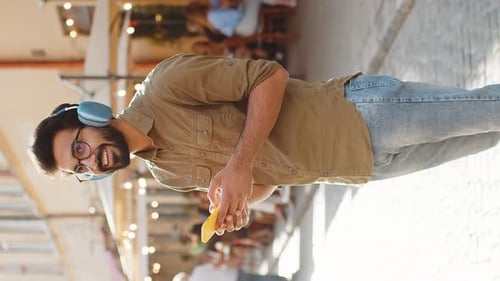 Young Adult Smiling and Using Phone in City