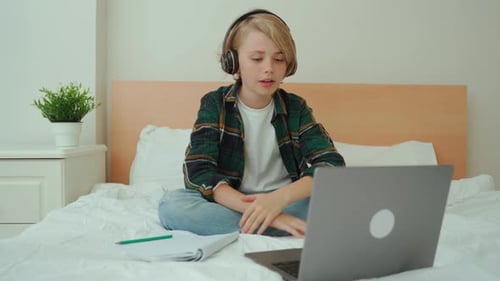 Boy with Laptop and Headphones at Home