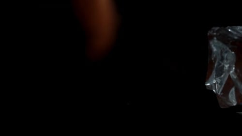 I pour nachos chips from the bag into a plate. View from below as if they are flying towards me, slo