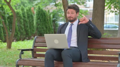 Mature Adult Businessman Giving Thumbs Down with Laptop Outdoor