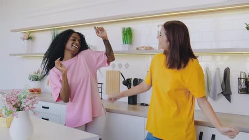 Two Young Women Dancing and Laughing in Kitchen