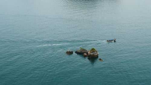 Slow Motion Shot of Motorboat in Ocean Waters Near Tropical Rocks