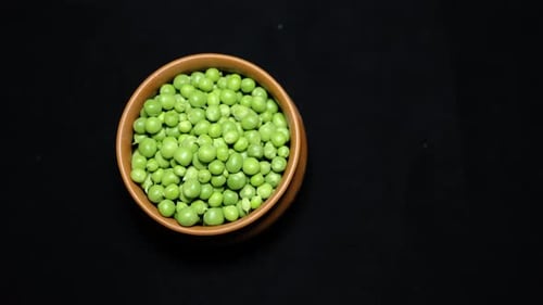 Fresh Green Peas Peeled in ceramic bowl Close-Up on Black Background studio shot