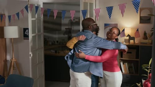 Happy African American Family of Spouses and Son Hugging after Decorating Home