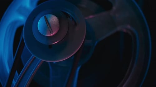 Vintage Film Projector Mechanism Rotating Under Blue Light