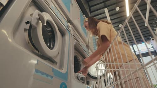 Woman Loading Clothes into Washing Machine