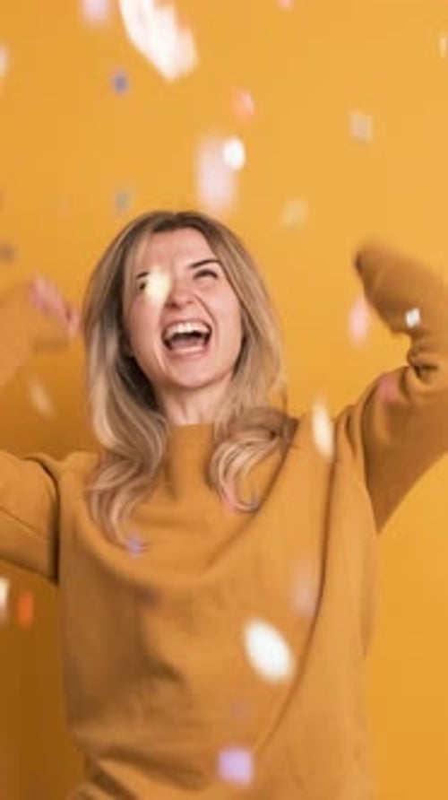 Cheerful Woman Celebrates with Colorful Confetti