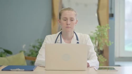 Female Doctor Working on Laptop in Clinic