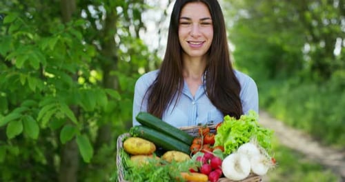 Beautiful young girl holding a basket of vegetables, in the background of nature. Concept: biology