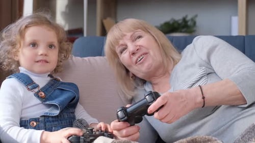 Grandmother and Girl Playing Video Games at Home