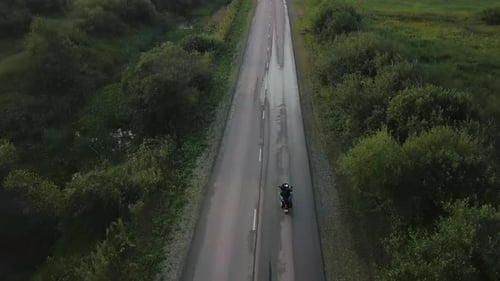 Aerial View of Motorcyclist Riding on Wet Country Road Clip