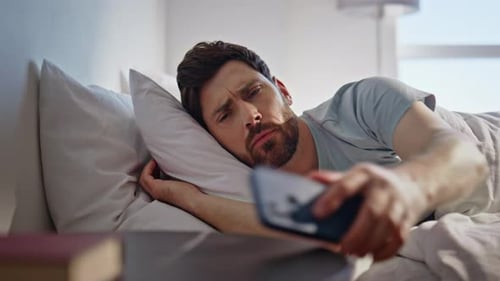 Man Sleeping, Wakes Up and Reaches for Phone