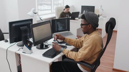 Jeune homme noir moderne au travail au bureau