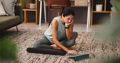 Woman Using Tablet While Exercising at Home
