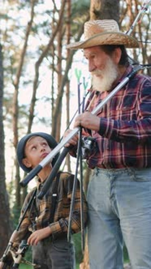 Senior Man and Boy in Woods with Fishing Rods