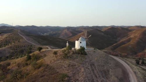 aerial footage of a windmill on a hill. wind power plant. video of hills and wind resources as energ