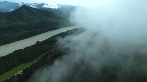 Aerial footage mountain peaks shrouded in fog.