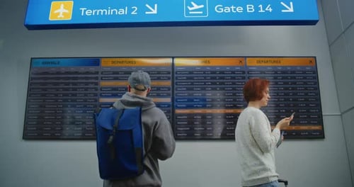 Travelers Check Flight Information on Airport Display