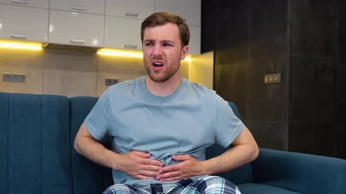 Man Suffering From Abdominal Pain on Sofa