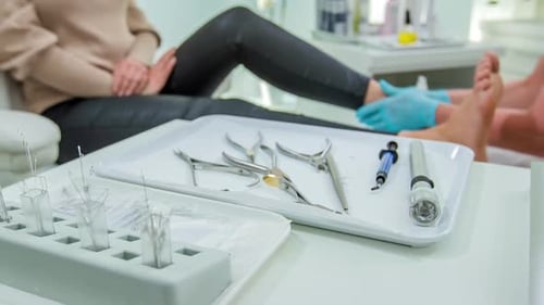 Podiatrist Examining Woman's Foot in Clinic