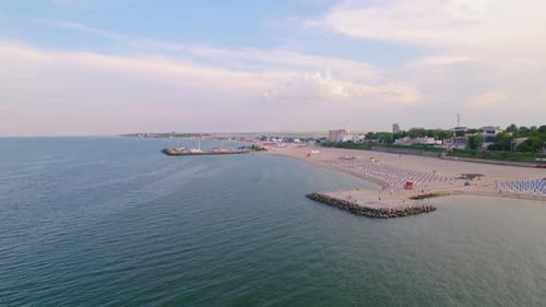 Aerial view of beach and sea with waves.