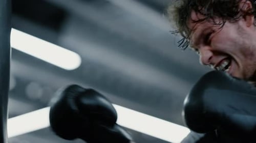 Eager kickboxer training blows at gym before fight in sport club portrait
