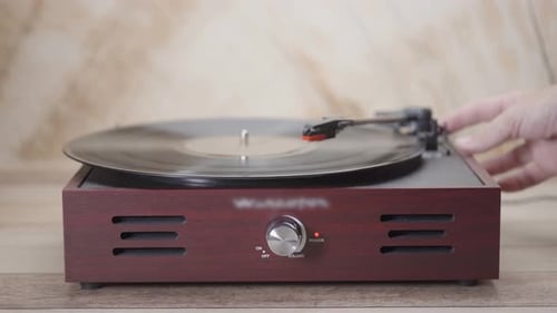 Hand Placing Needle on Vintage Record Player