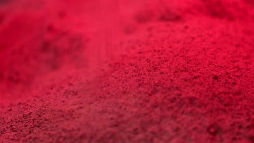 Crimson Powder Drops Onto Red Material