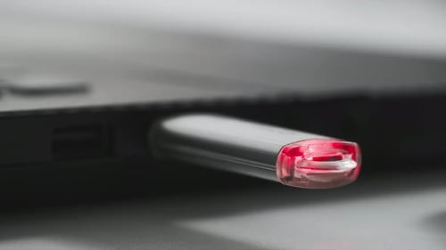 Technology Woman Hand Includes a Flash Drive for Data Transfer in a Laptop Red Light Flashes on a