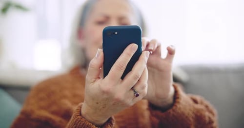 Senior Woman Using Mobile Phone Indoors Close Up